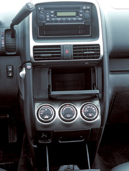 Honda CR-V: Справа на консоли действительно поручень, а слева – замаскированный под поручень рычаг стояночного тормоза. Между ними ящичек, на месте которого европейцы и японцы наблюдают экран навигационной системы